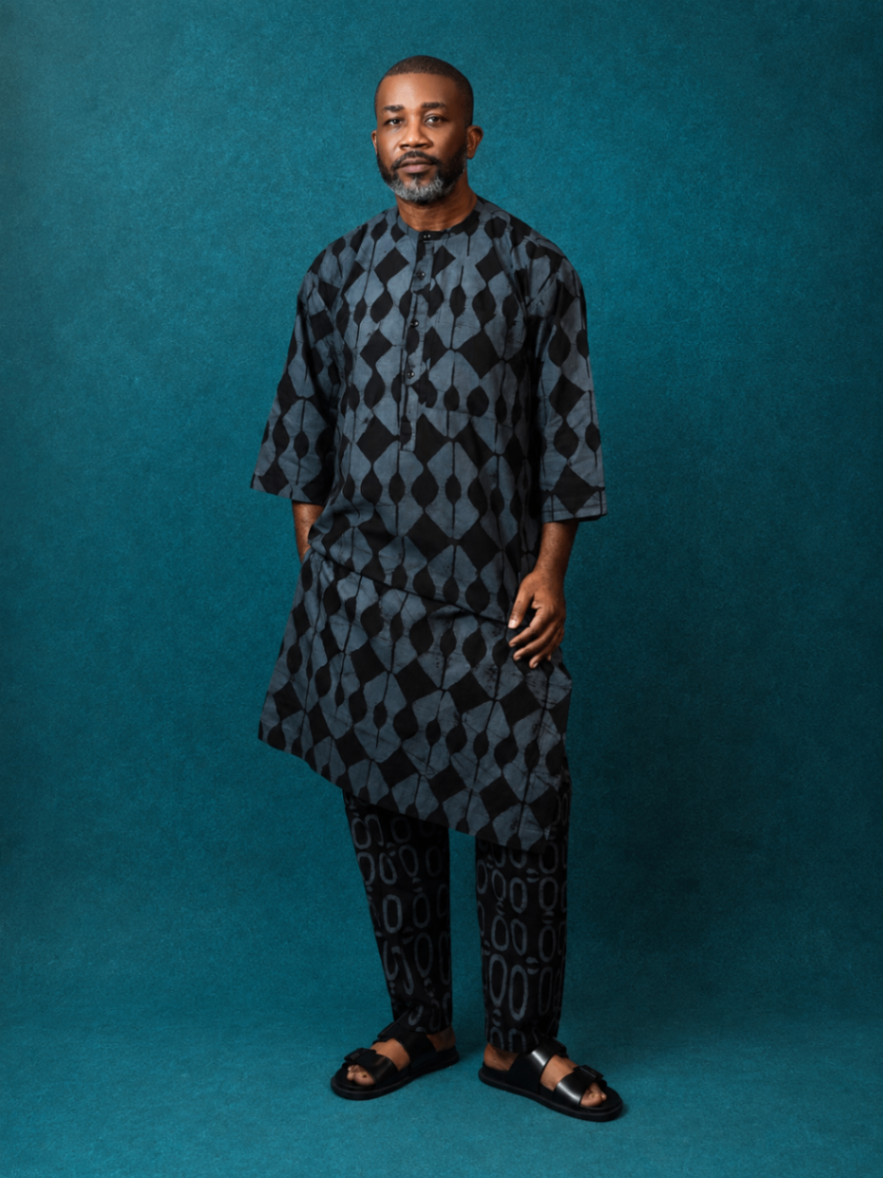 Model wearing an OBIDA dark kaftan set against a teal studio backdrop.